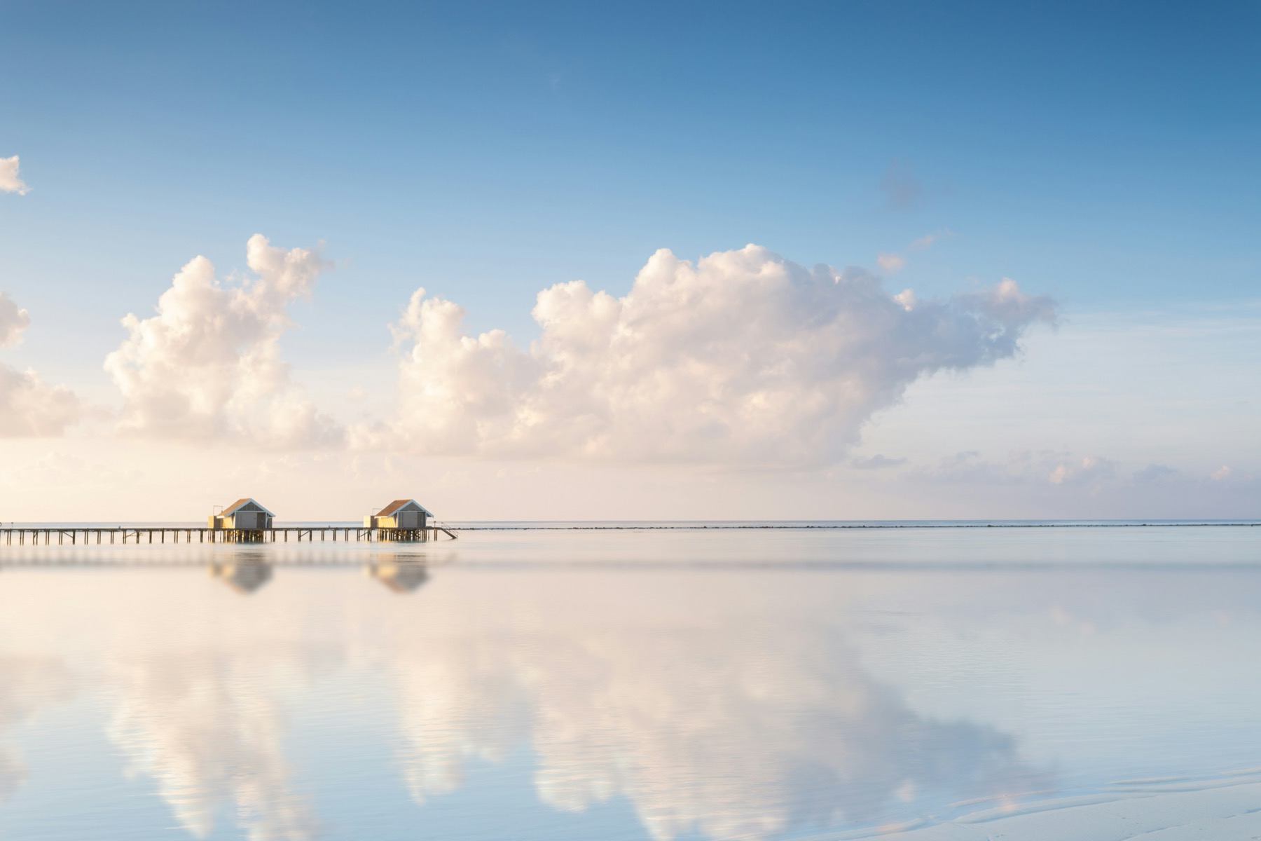 Overwater villas under a clear sky representing Black Tomato luxury travel
